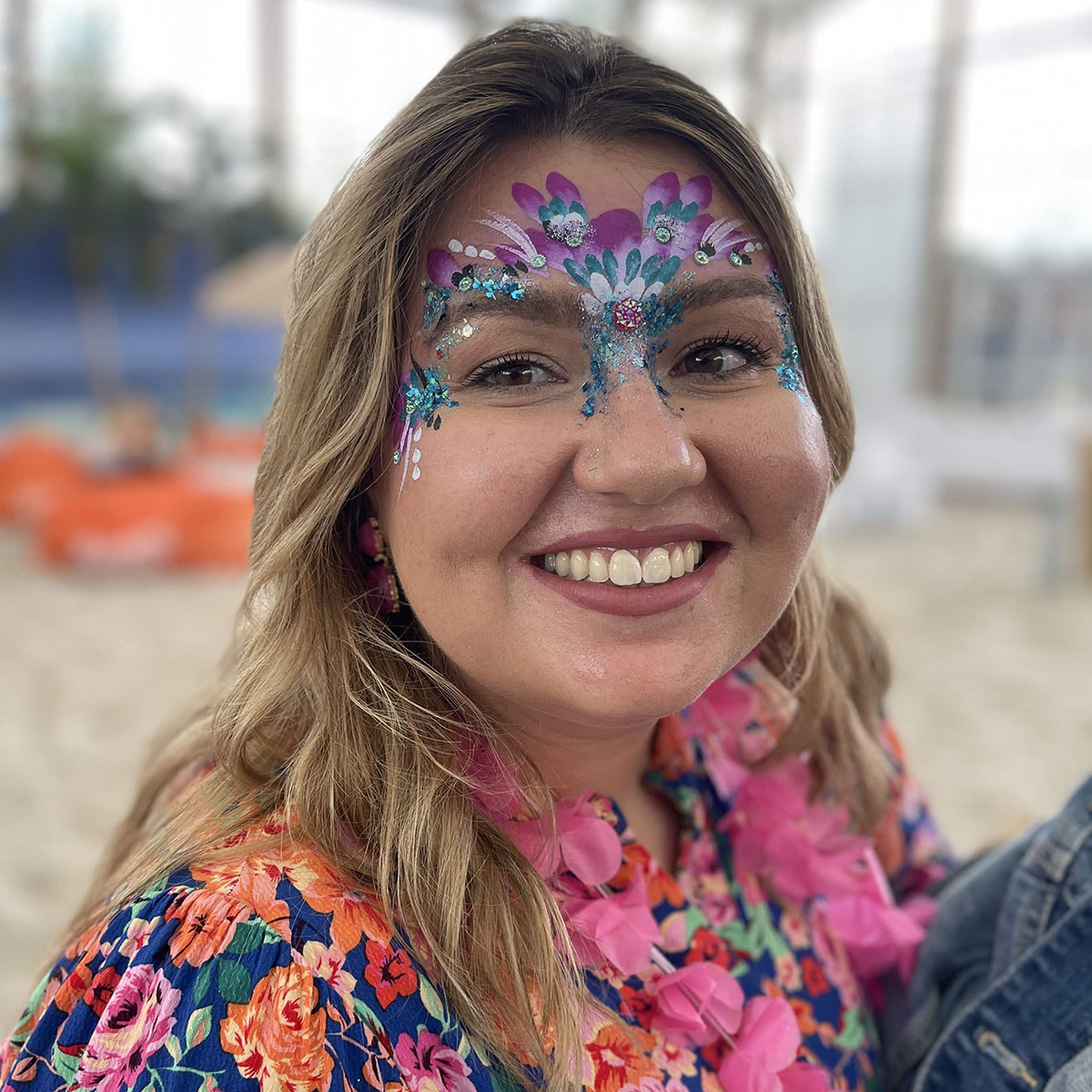 Blonde Frau mit einem farbenfroh bemalten Gesicht. Facepainting.